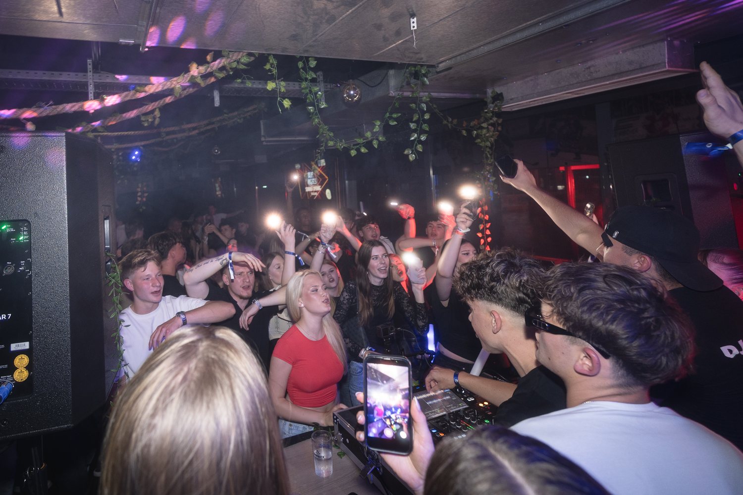 Gäste tanzen und singen nah am DJ-Pult mit